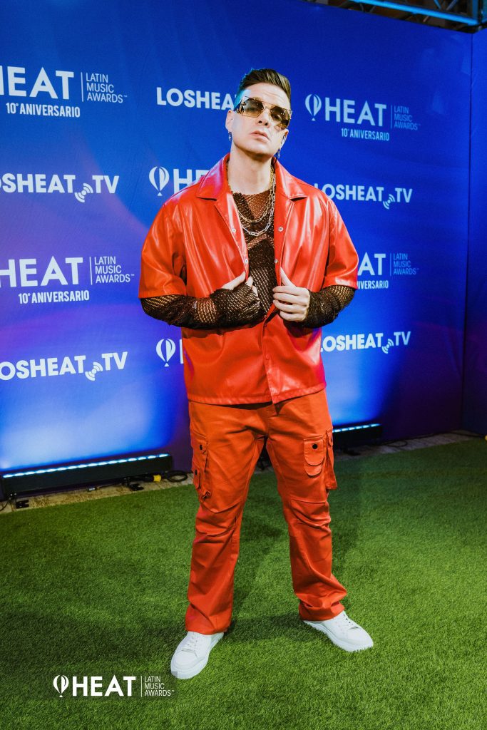 El afamado creador de contenido venezolano Marko, de rojo y negro con un look moderno fiel a la esencia de esta fiesta. El artista fue conductor del la Alfombra Heat y de la gala, así como también un ganador Heat al imponerse en la categoría Mejor Contenido Plataforma Musical. Muy merecido por su talento y arrolladora personalidad, un artista de la casa Heat.